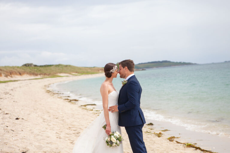 bride and groom forehead to forehead on beach
