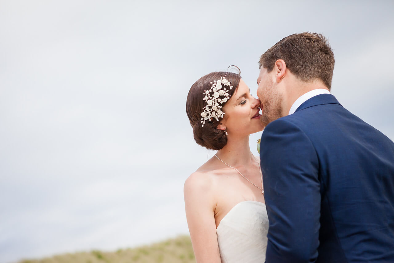 bride and groom kissing on beach