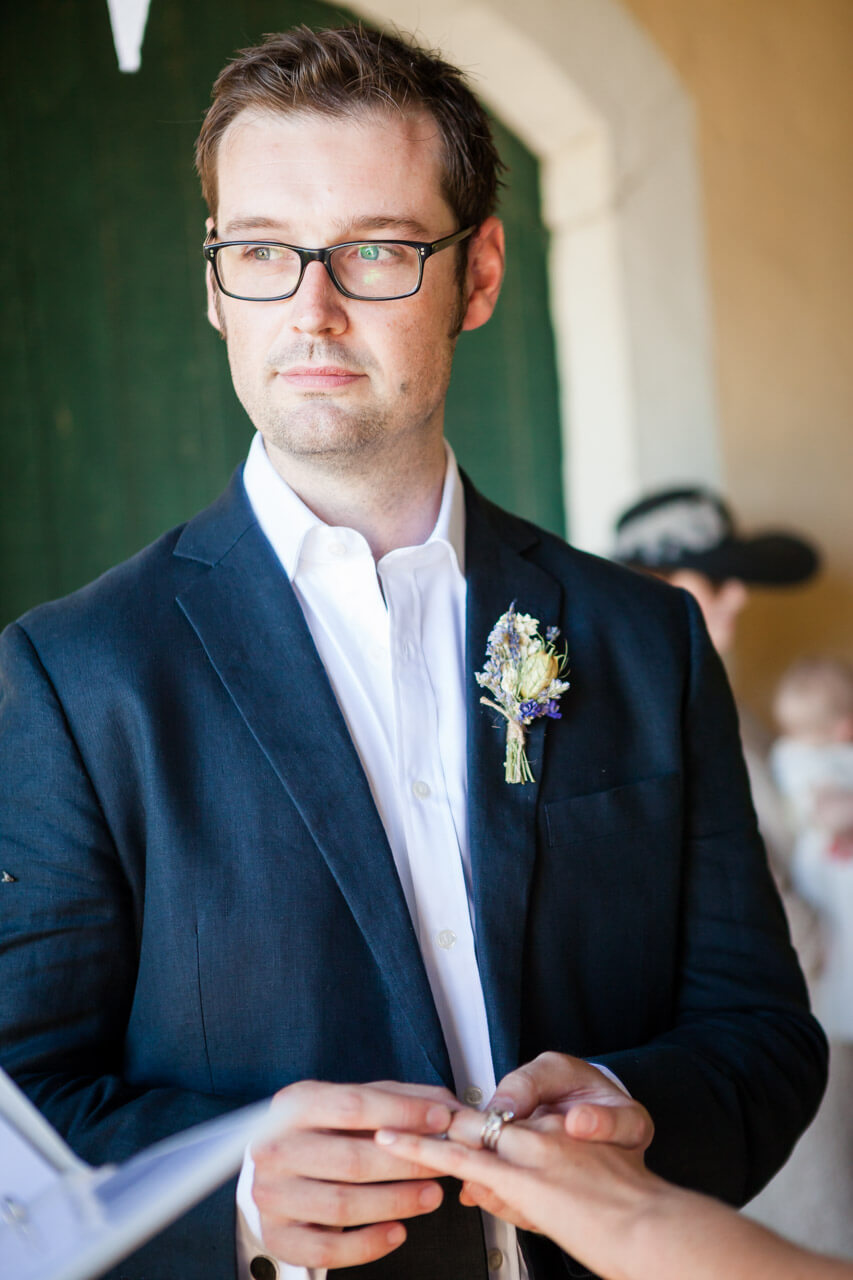 groom placing ring on bride