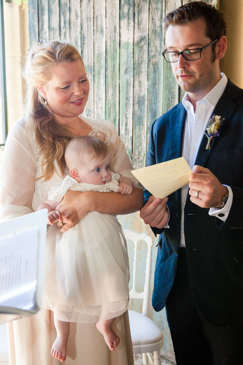 bride and groom and their baby reading