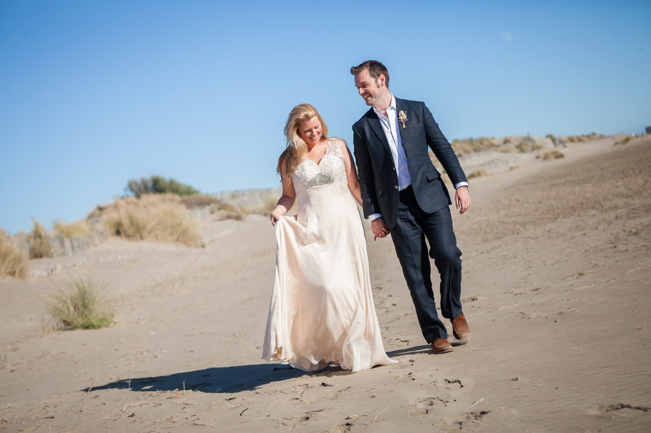 bride and groom walking along beach