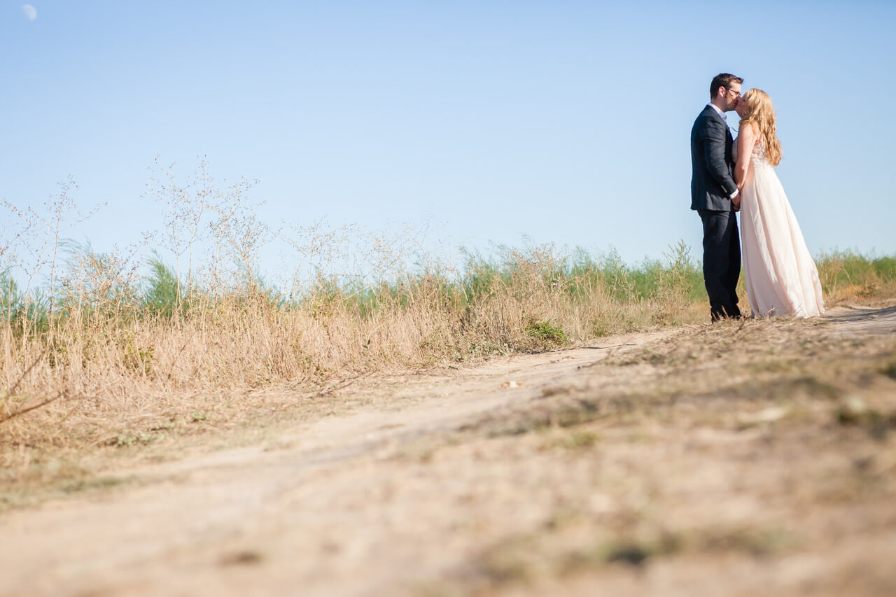 bride kissing groom on country lane