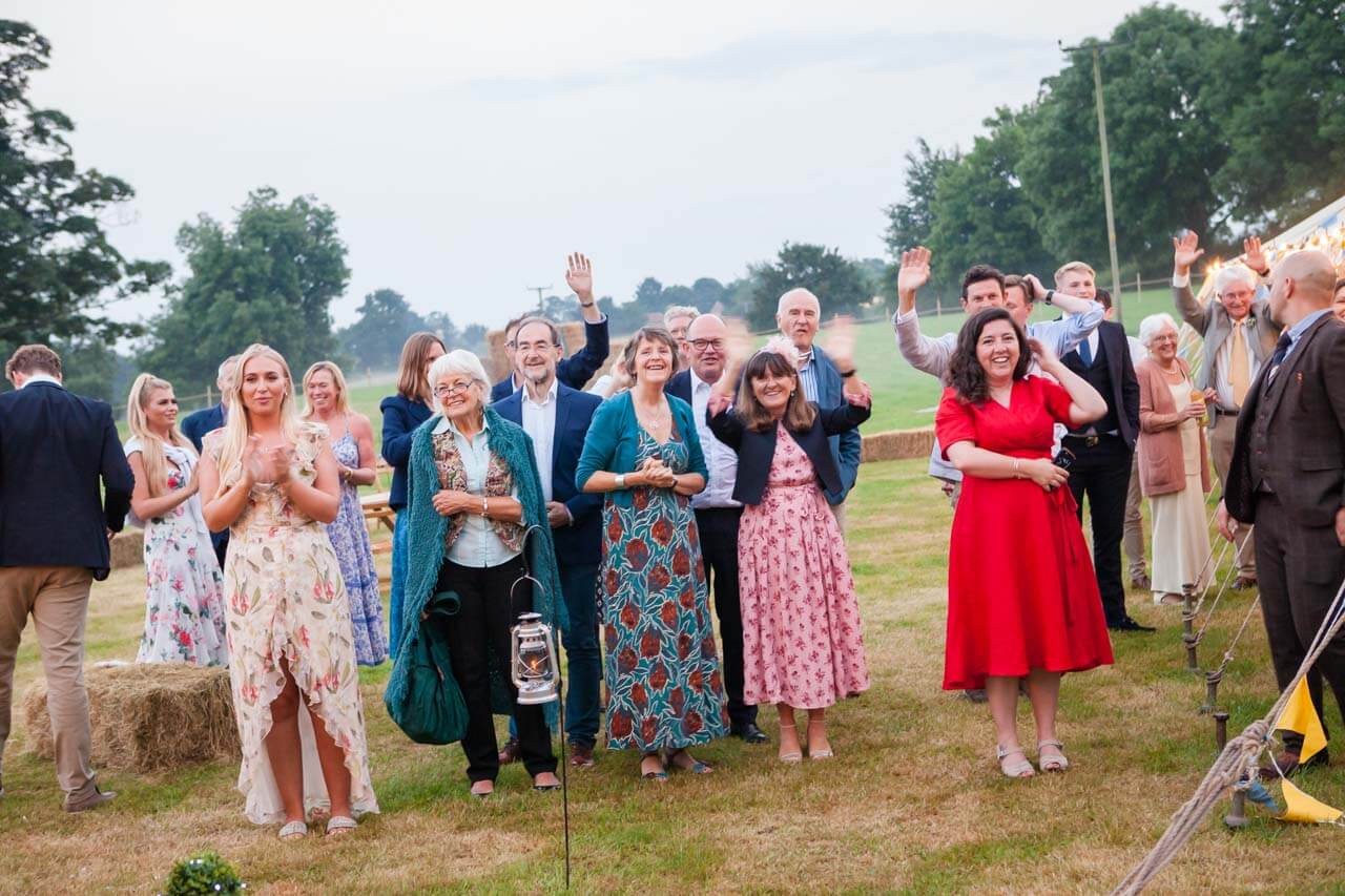 guests wave off groom and bride