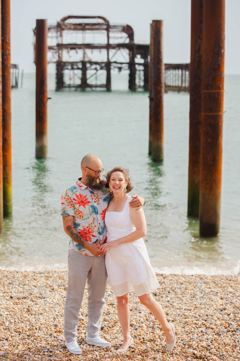 west pier in background couple standing looking into camera