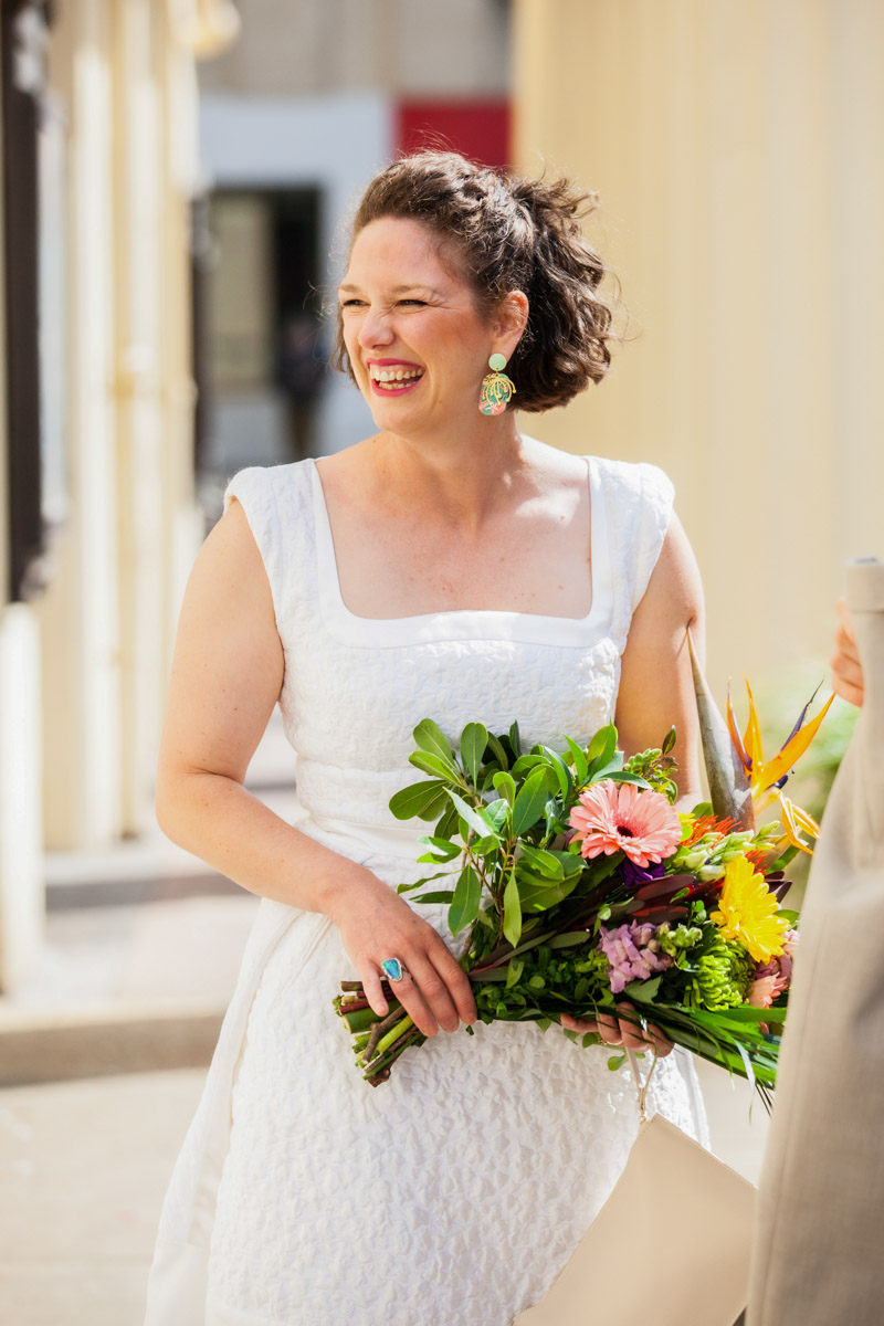 bride looking away from camera smiling holding flowers