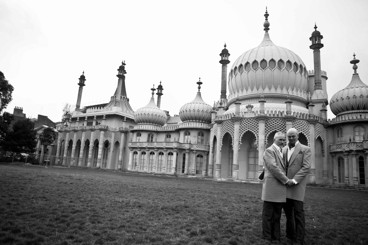 photo of two grooms standing holding hands in royal pavilion gardens