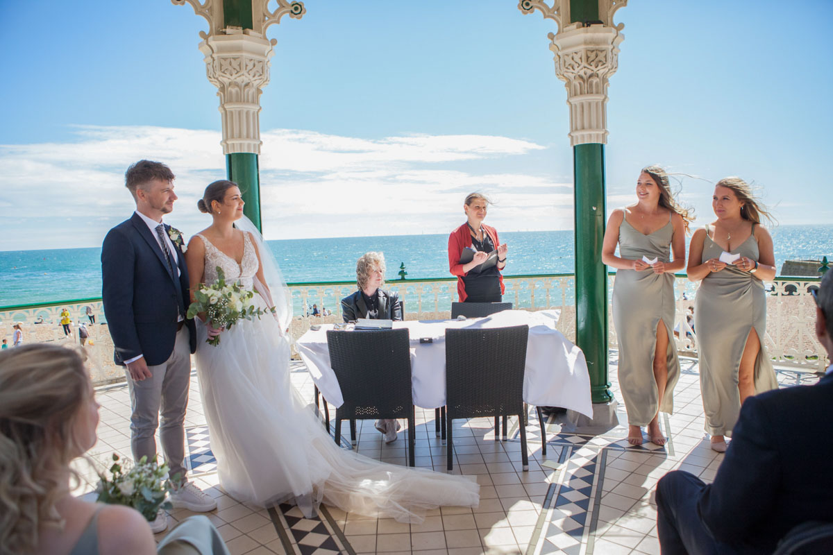 bride and groom listening to registrar during their ceremony on Brighton bandstand