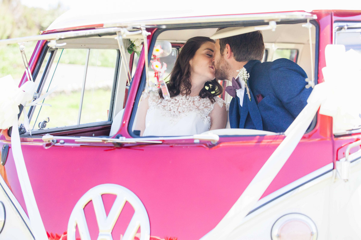 couple kissing inside wedding campervan