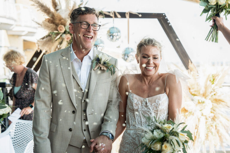 bride and groom walking through confetti