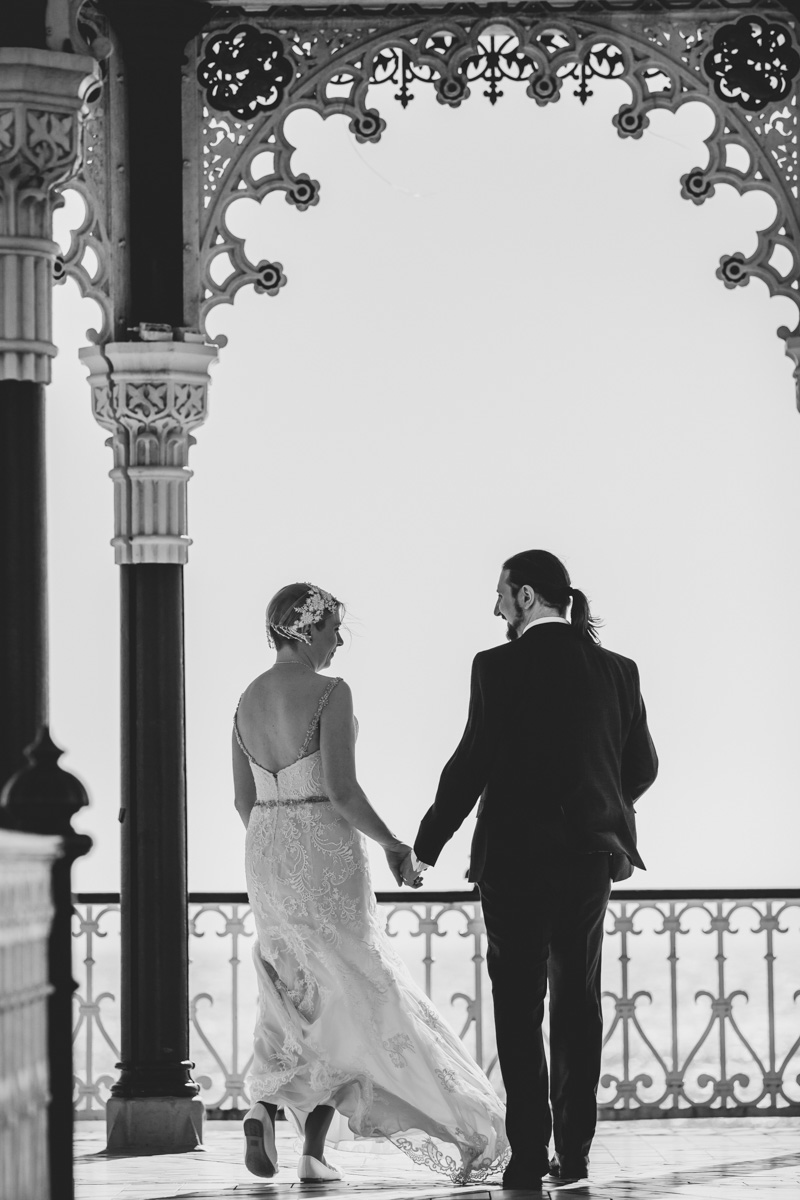 couple walking away from camera walking towards end of bandstand
