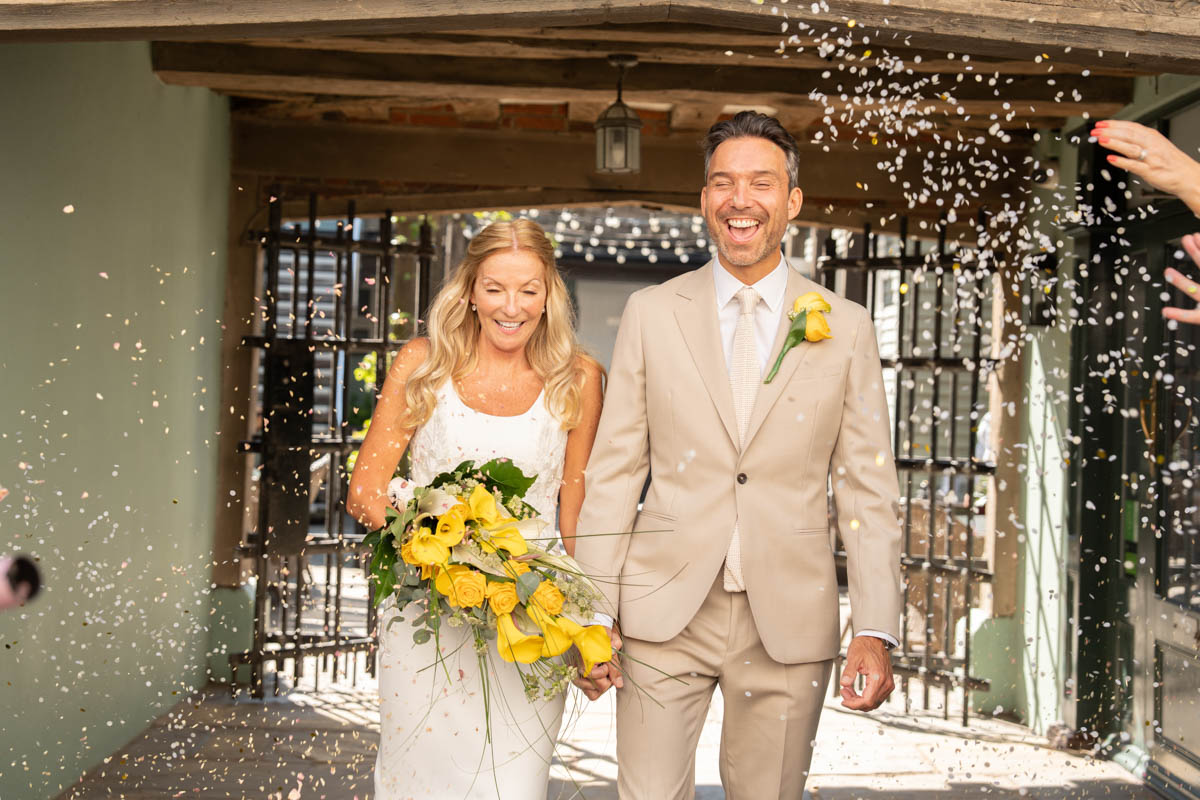 couple walking towards camera with confetti thrown at them