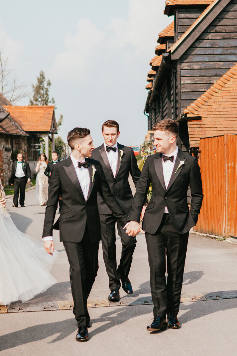 grooms and their party walking to the ceremony