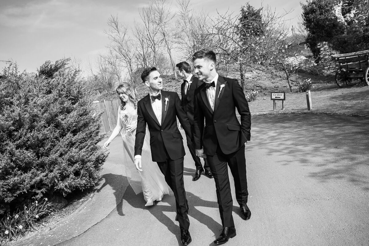 two groom holding hands walking to ceremony