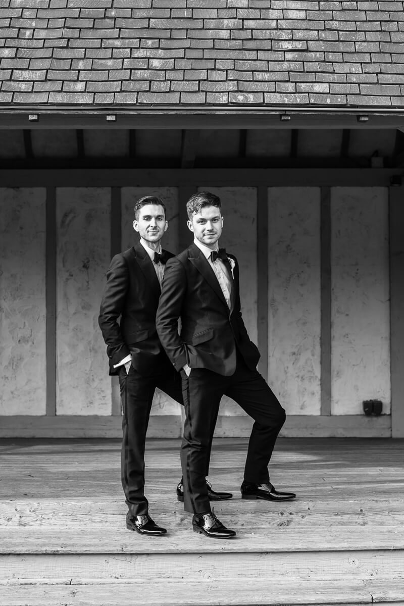 two guys standing on steps hands in pockets looking towards the camera