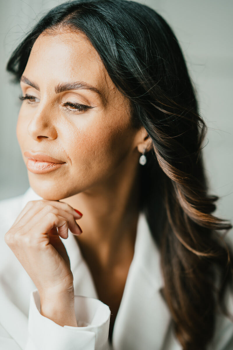 portrait of bride looking away from the camera poised with hand on chin