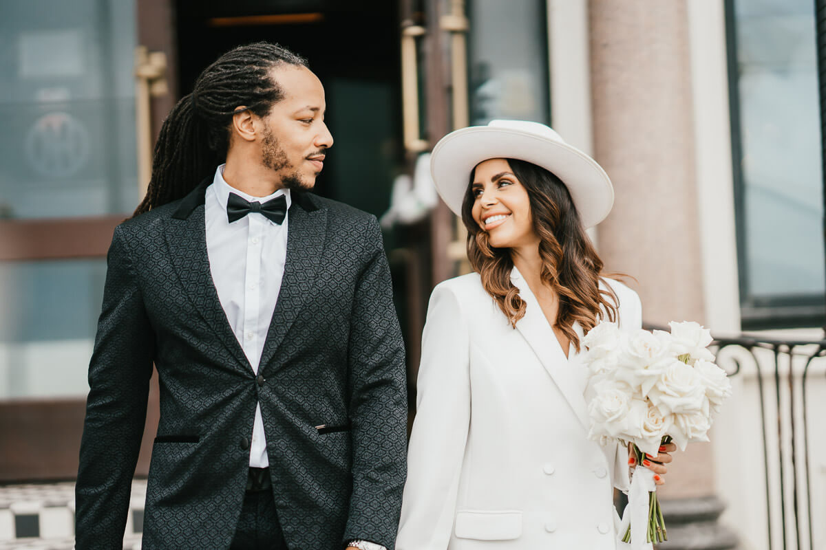 bride and groom walking down hotel steps looking at each other