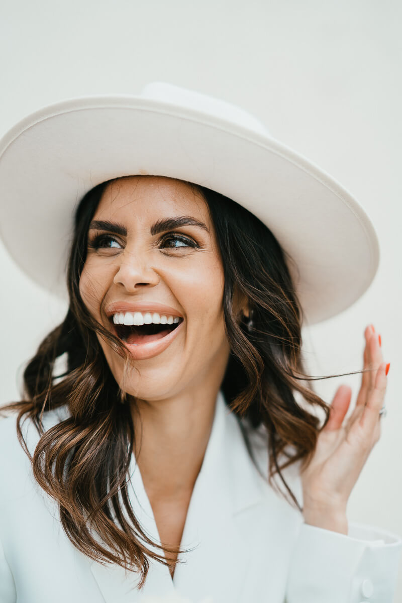 portrait of laughing bride with hand holding back hair in the wind