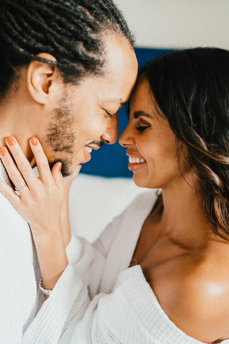 bride and groom cup each others faces smiling foreheads and noses together
