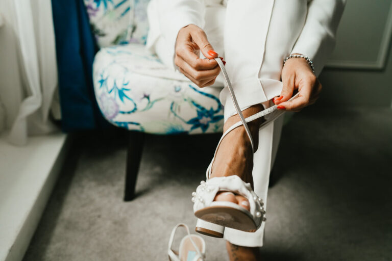 close up of bride doing up her shoes