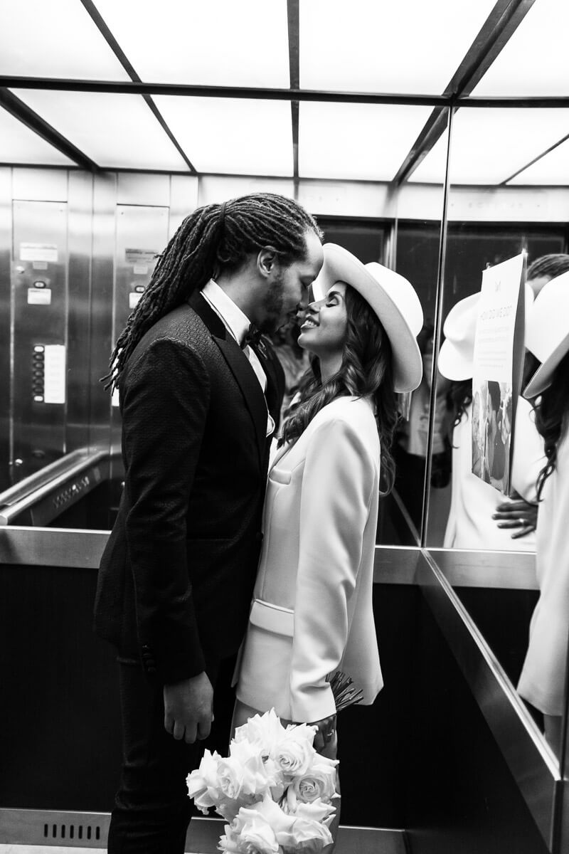 bride and groom sneak a kiss in lift down to the hotel lobby