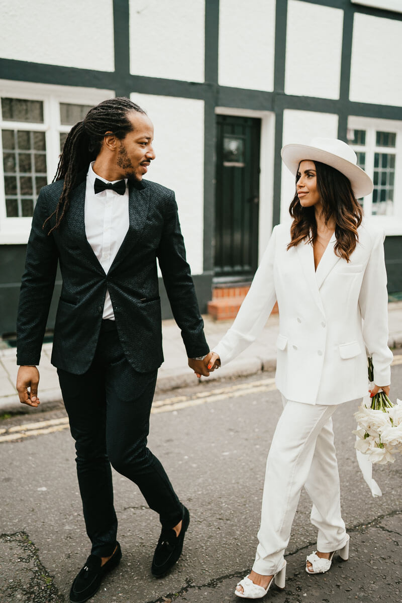 groom leads bride down street holding hands