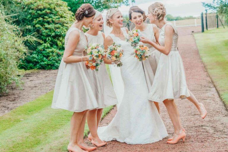 group of bridesmaids standing close together smiling and laughing with each other