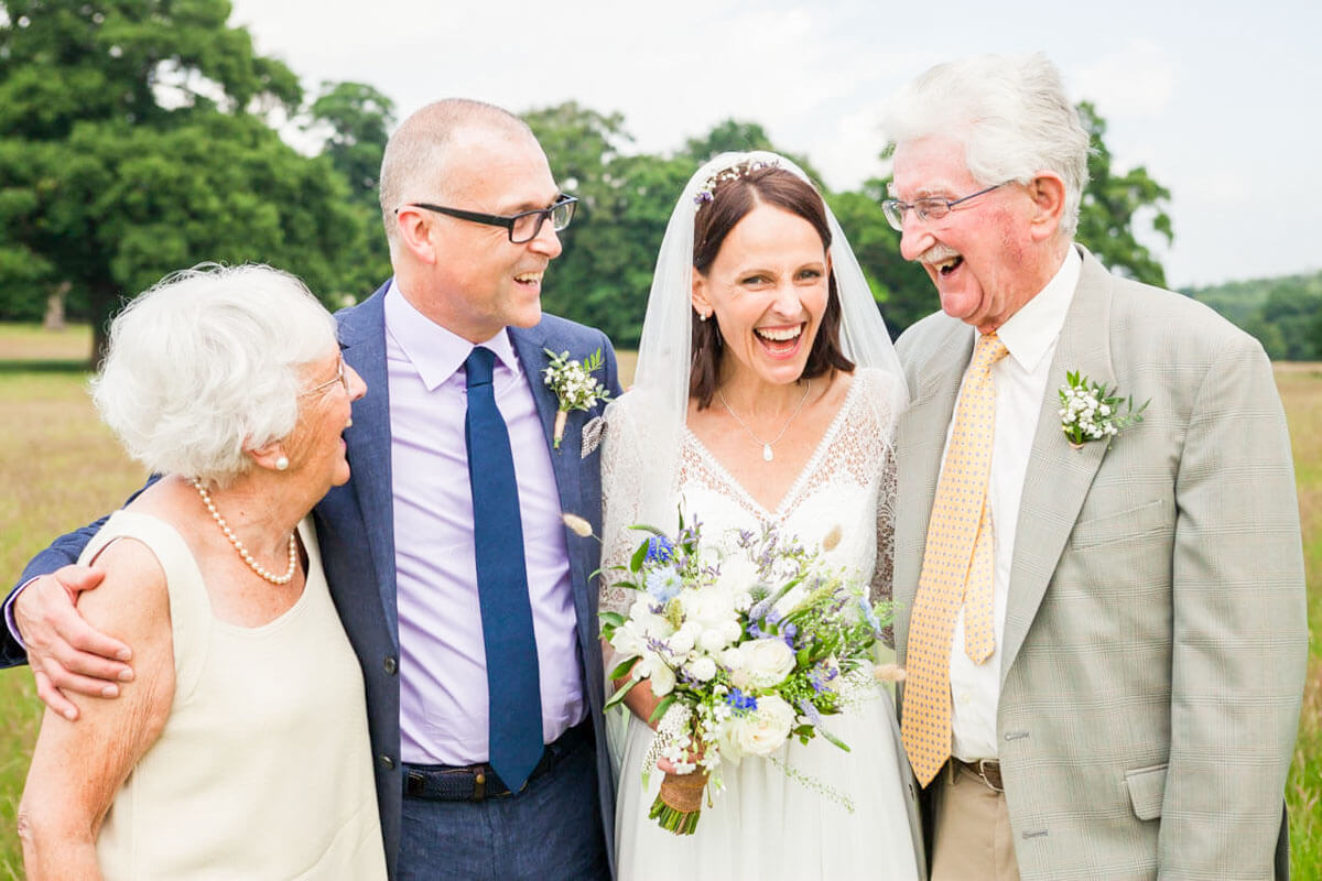 bride groom and parents enjoying a joke during their group photo
