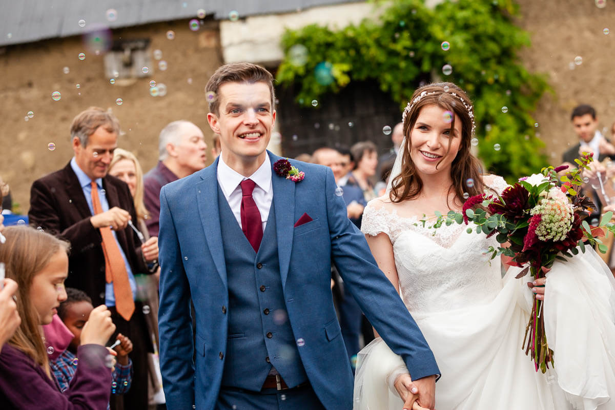 bride and groom walking through the bubble confetti line