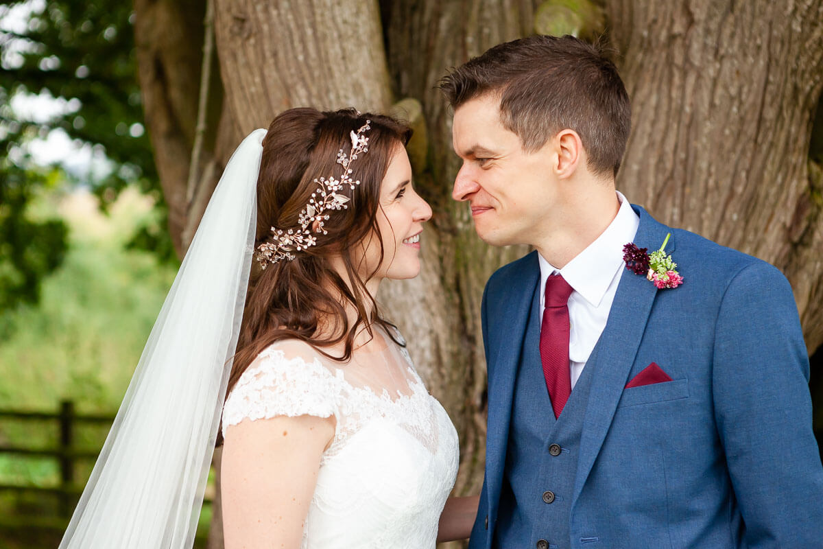 bride and groom looking towards each other with giant tree in the background