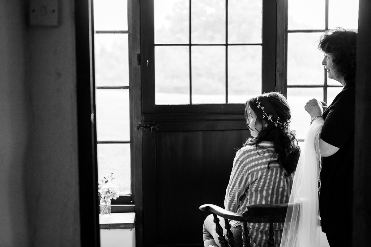 back of bride sitting in a chair look to the left.