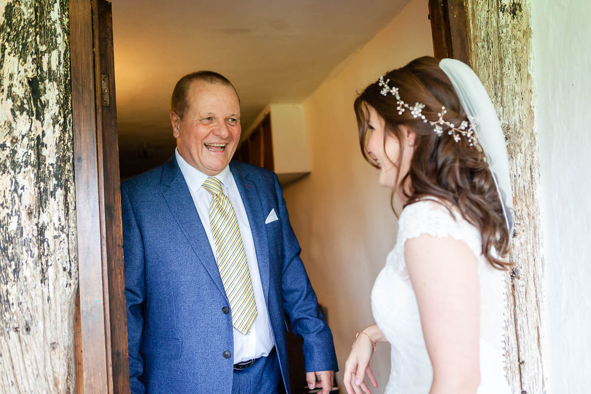 father sees his daughter for the first time in her dress. He's smiling big!