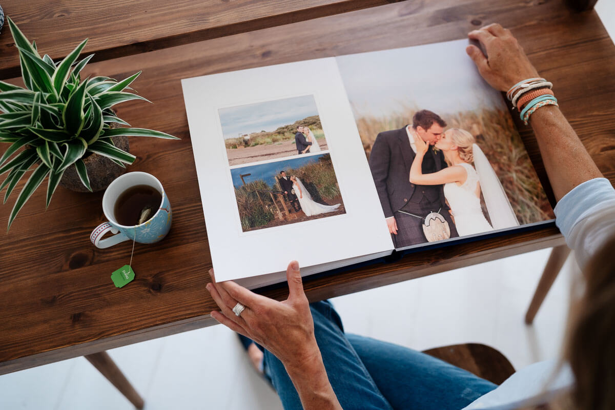 Birds Eye view of wedding album on wooden desk 