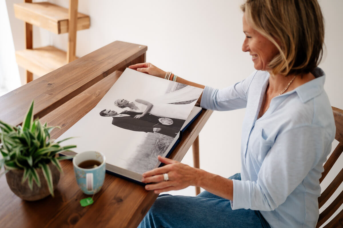 professional photographer flicking through wedding album on desk