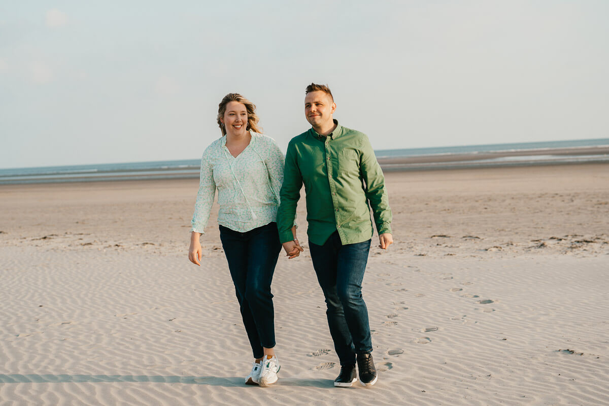 couple walking hand in hand along beach