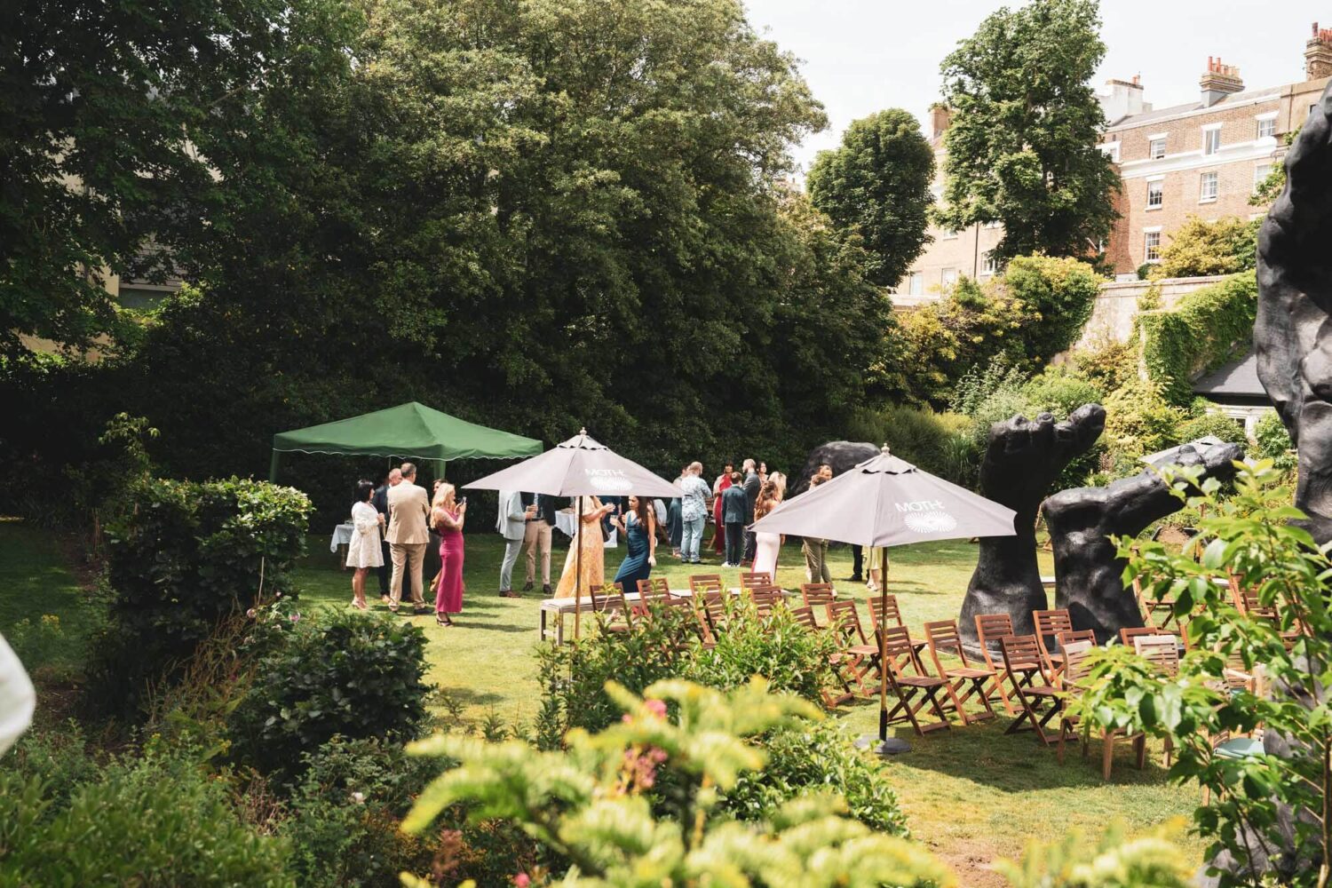 secret garden with trees and umbrellas and guests mingling