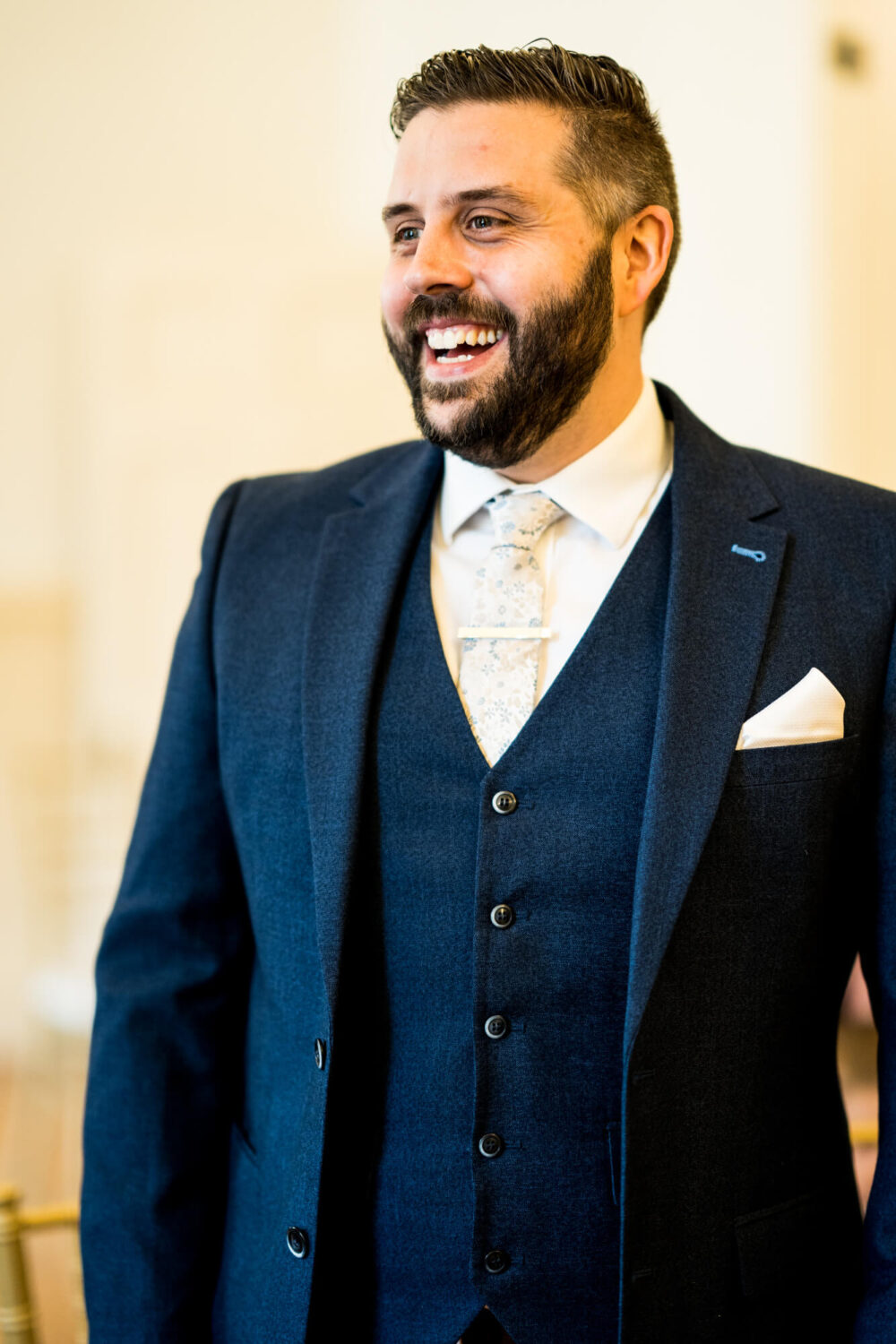 groom laughing looking off to the left