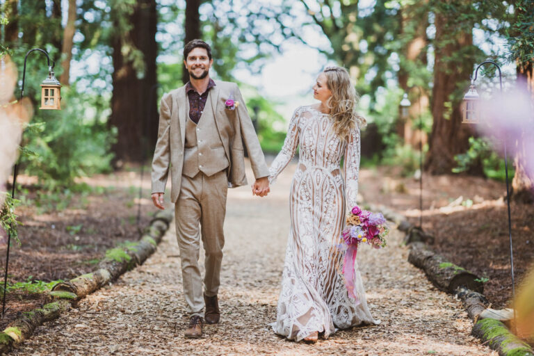 bride looking at groom walking along pathway in stunning redwood forest