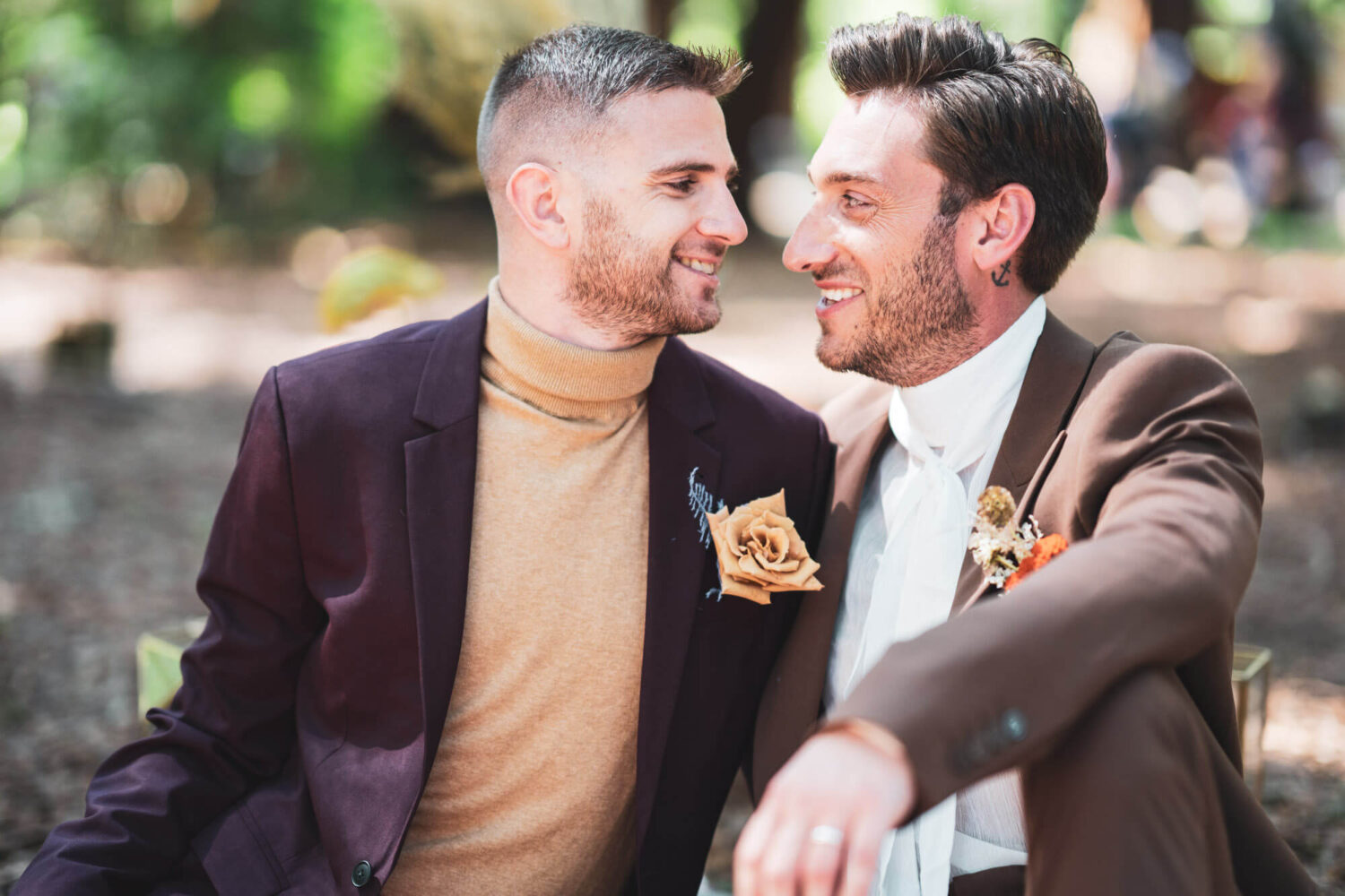 two grooms sitting looking into each others eyes