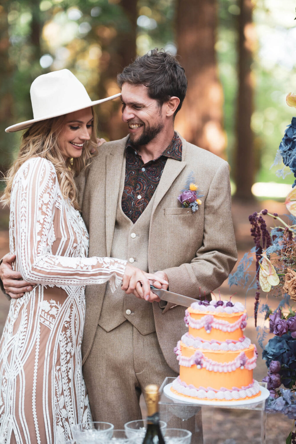 bride and groom cutting cake in forest