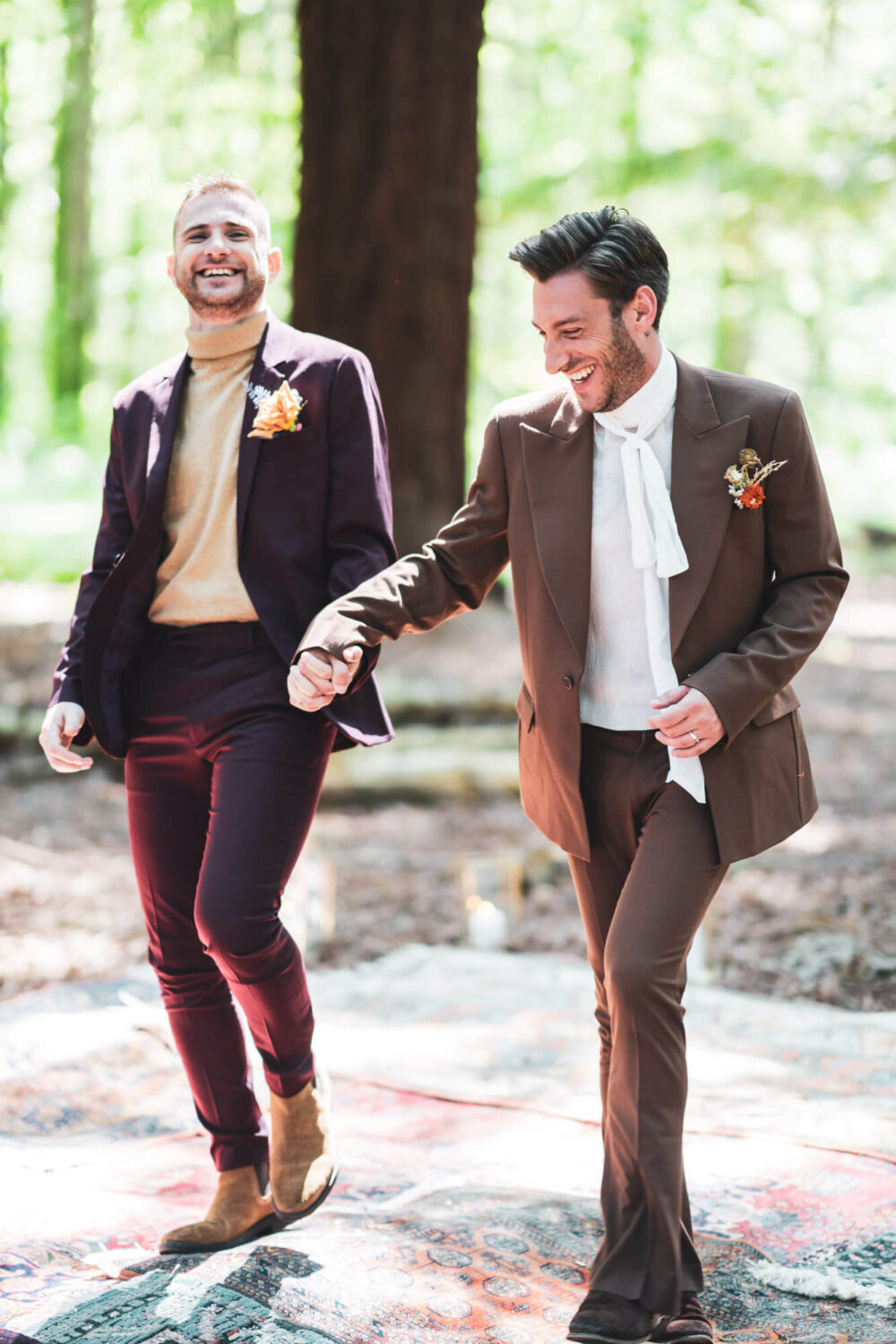 two grooms walking along laughing hand in hand