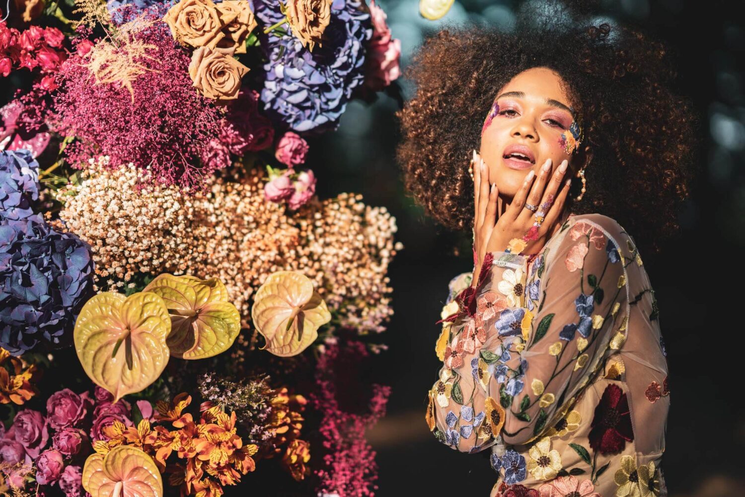 woman next to florals with amazing flower power make up