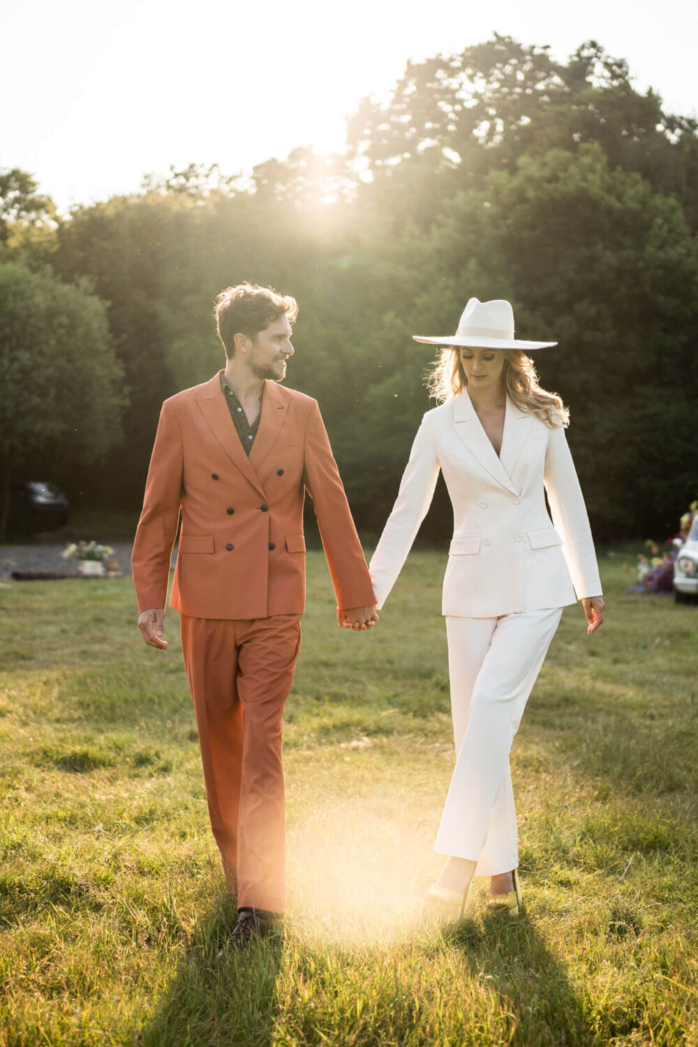golden hour portrait of bride and groom walking towards camera looking at each other