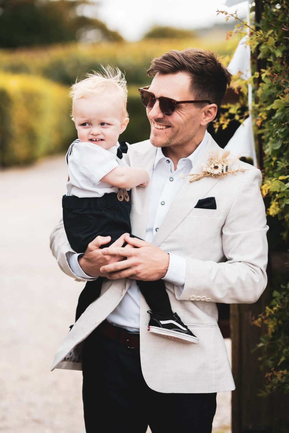 photo of groom holding his toddler son