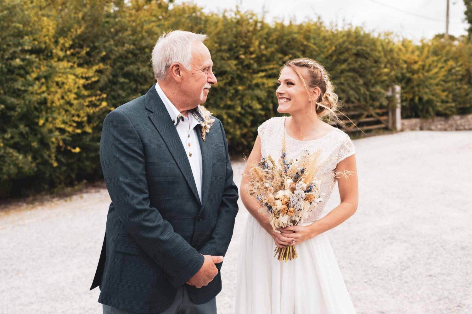 father of the bride and the bride smiling looking at each other