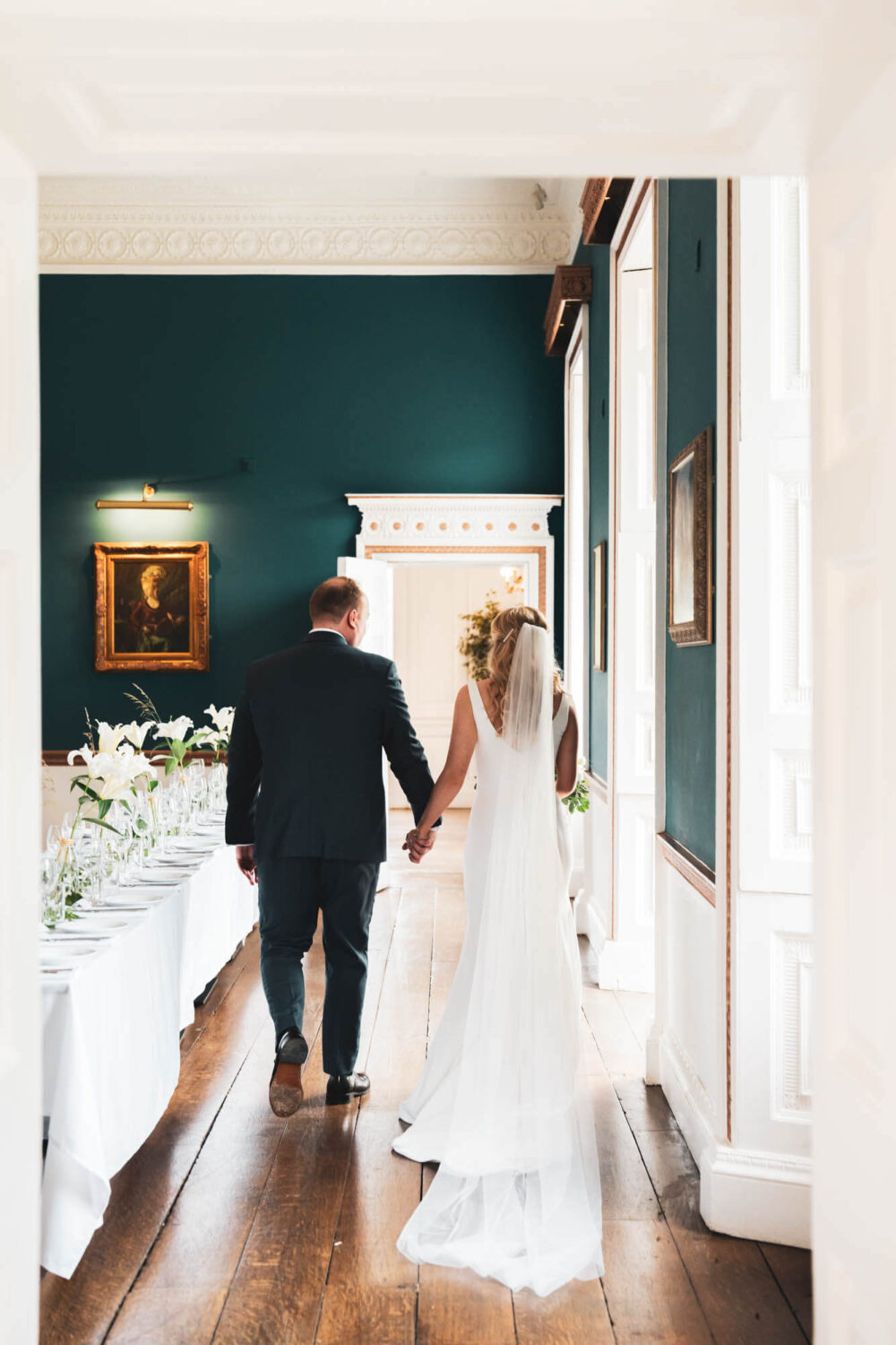 groom and bride walking away from the camera through goerigan dining room