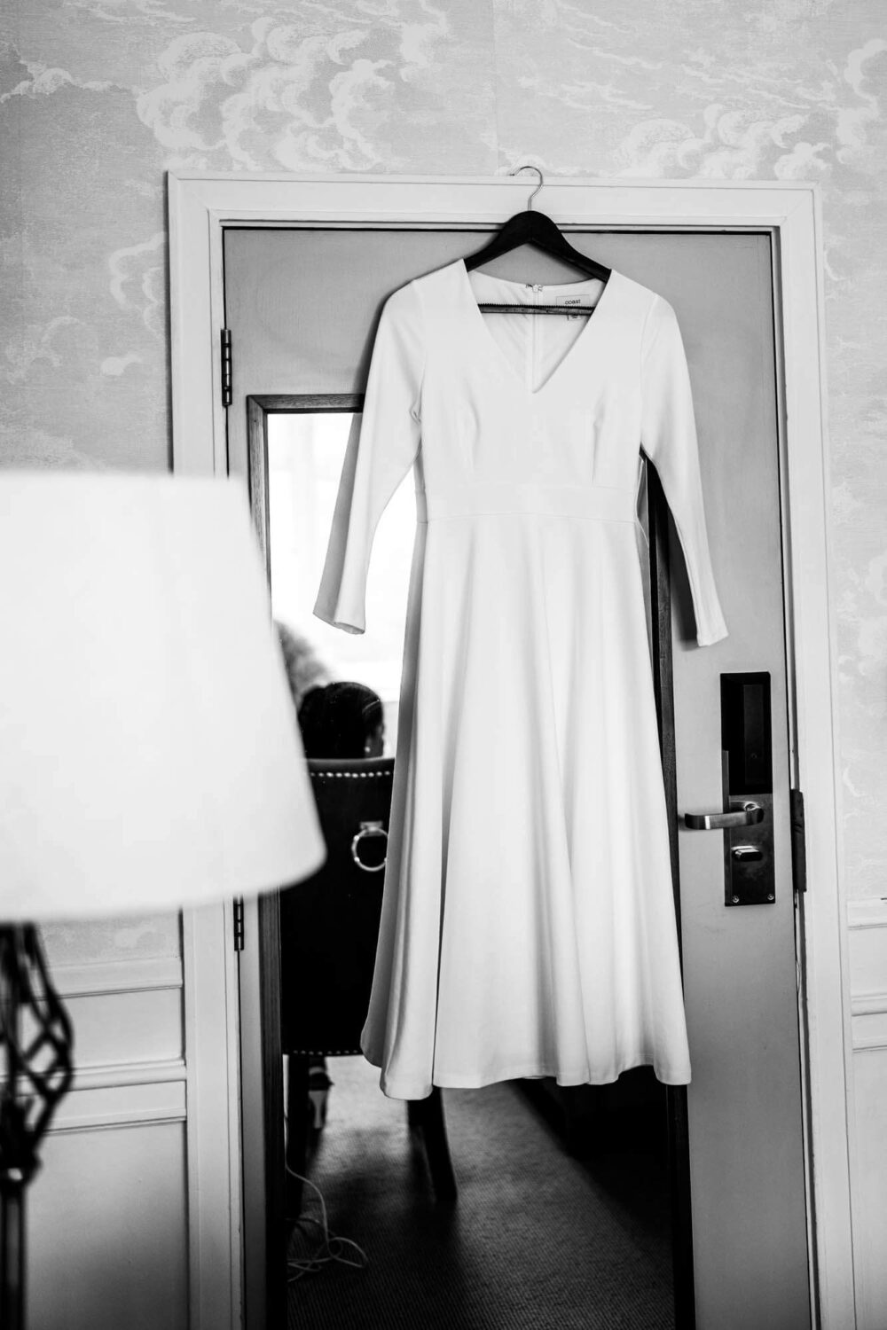 bridal dress hanging on hanger in front of mirror