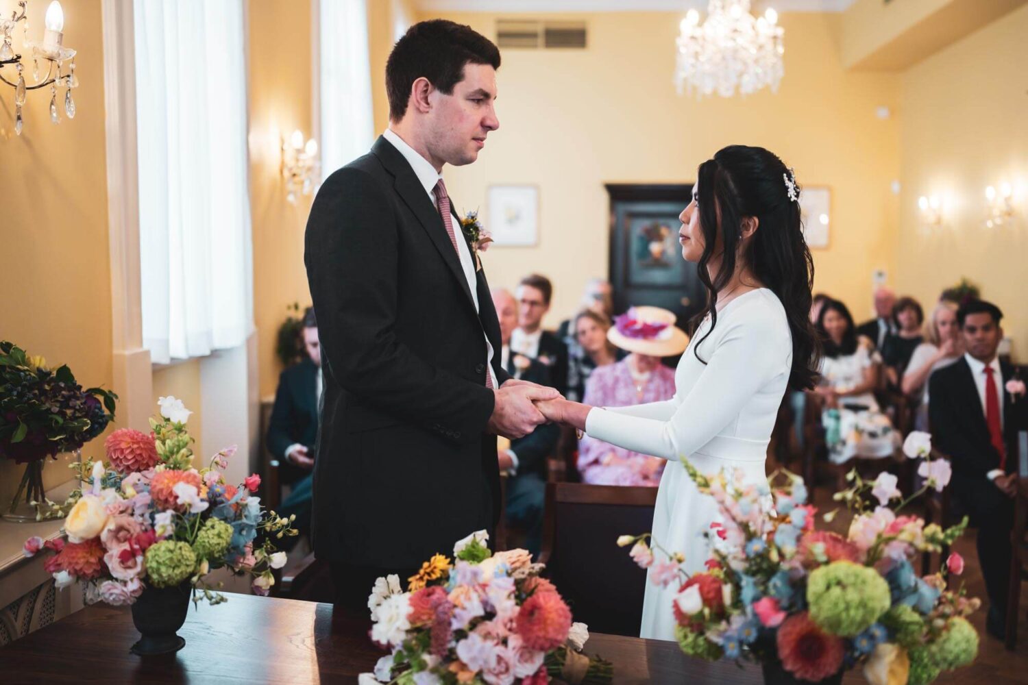 groom and bride holding hands looking into each others eyes