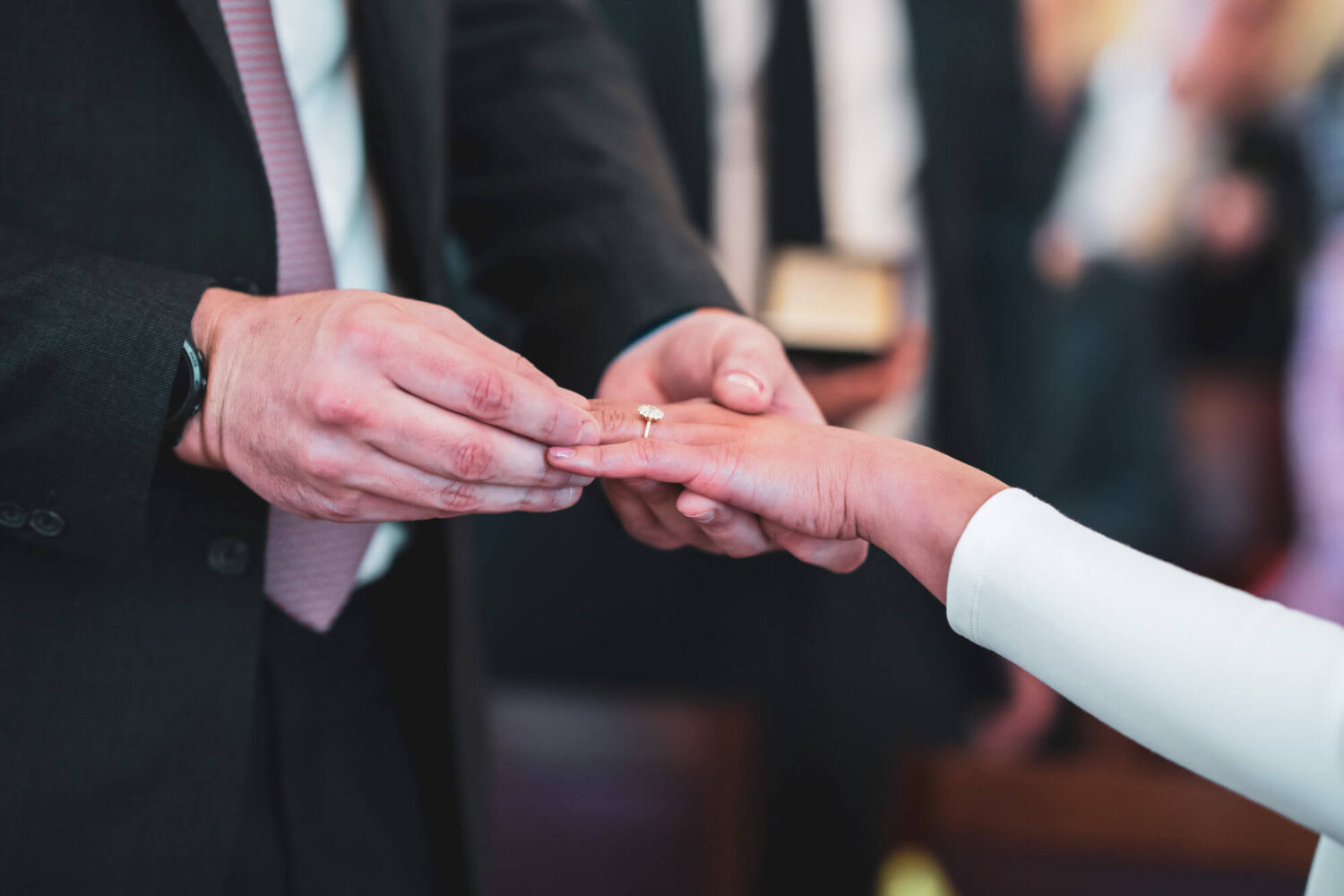 groom putting ring on bride's finger