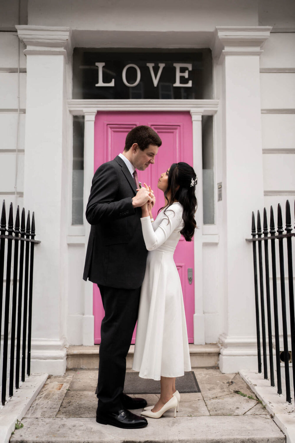 couple standing outside pink LOVE door in Chelsea