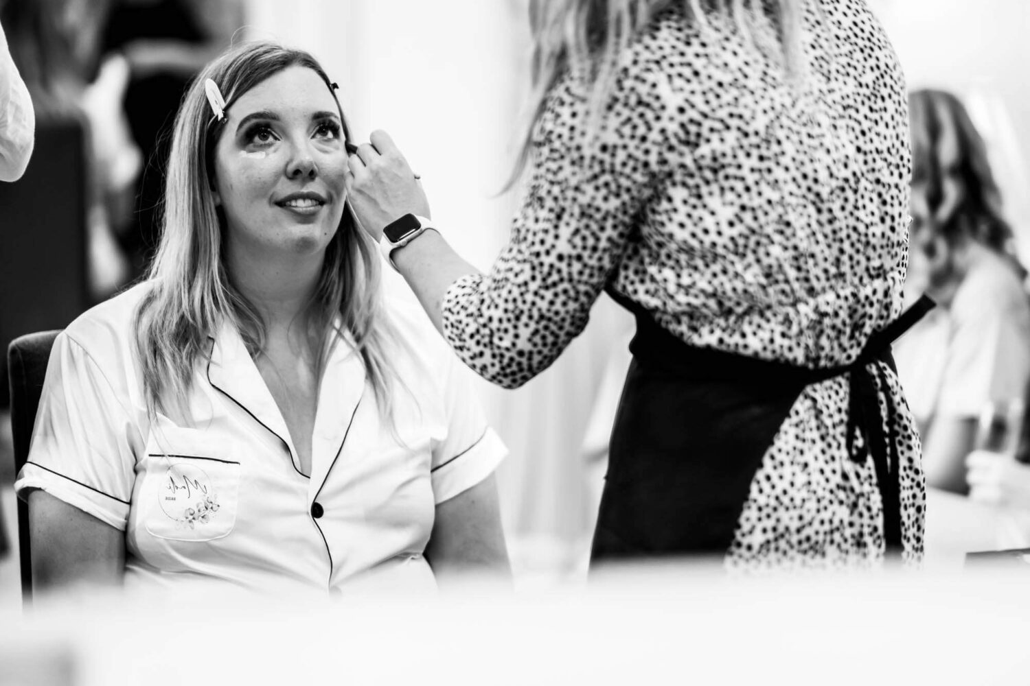 black and white shot of bride having eye make up put on